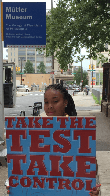 Person holding a poster promoting National Black HIV/AIDS Awareness Day. The Sign reads: &quot;Take the Test. Take Control&quot;