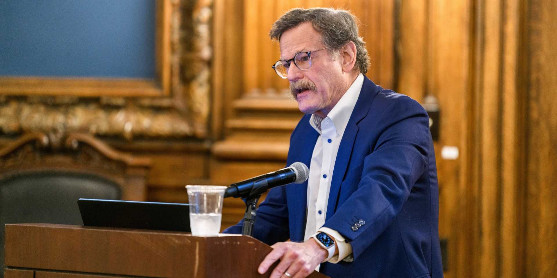 Dr. Kaiser at podium in blue suit