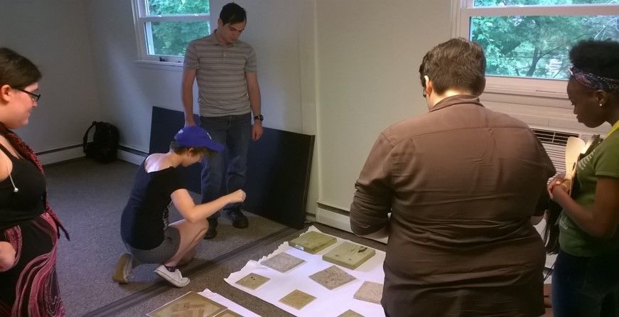 Students in the OUt4STEM internship program examine plaster molds of footprint impressions during a lesson on crime scene investigation at Arcadia University