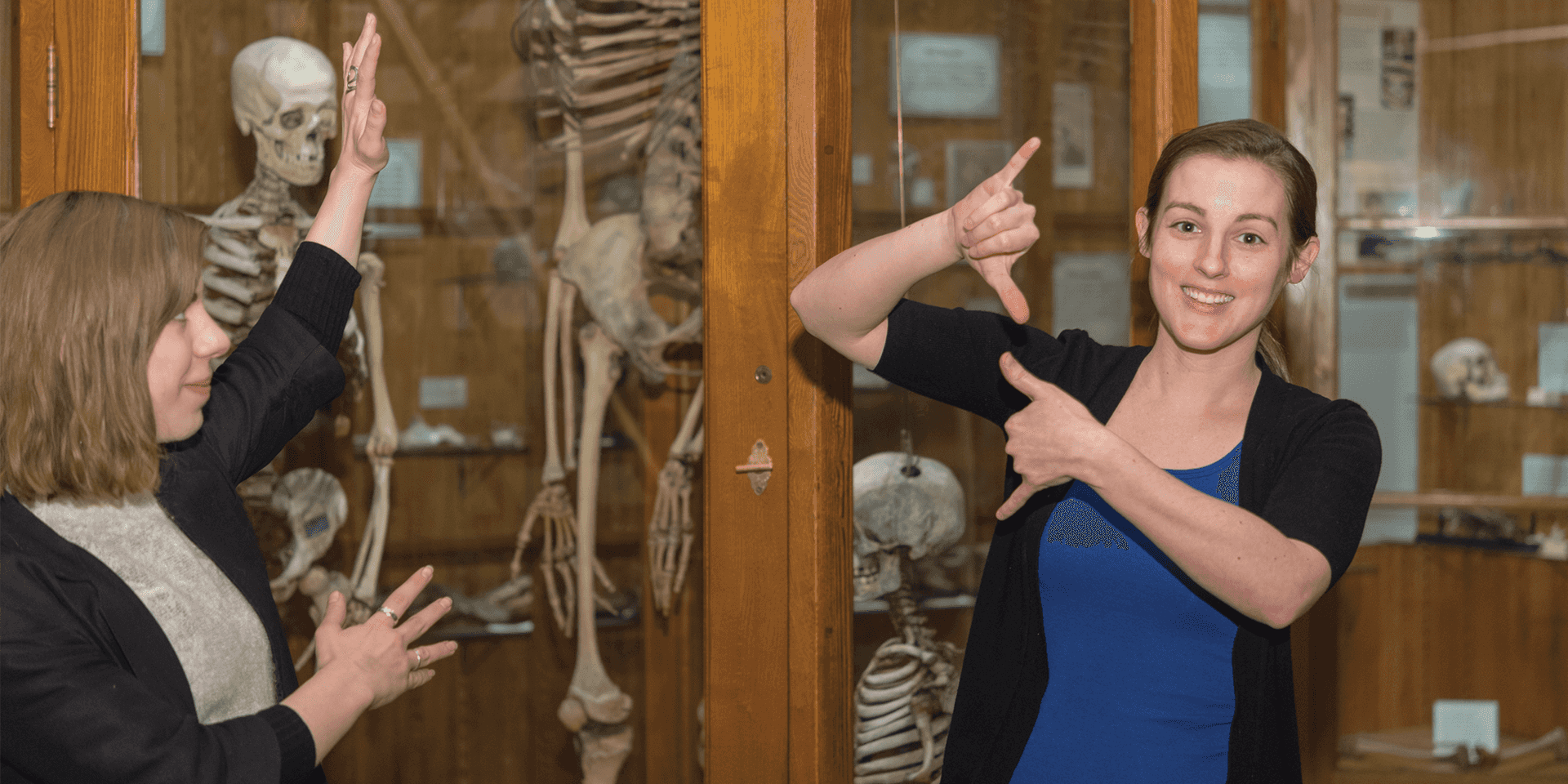 Woman in blue shirt doing American Sign Language in the museum gallery