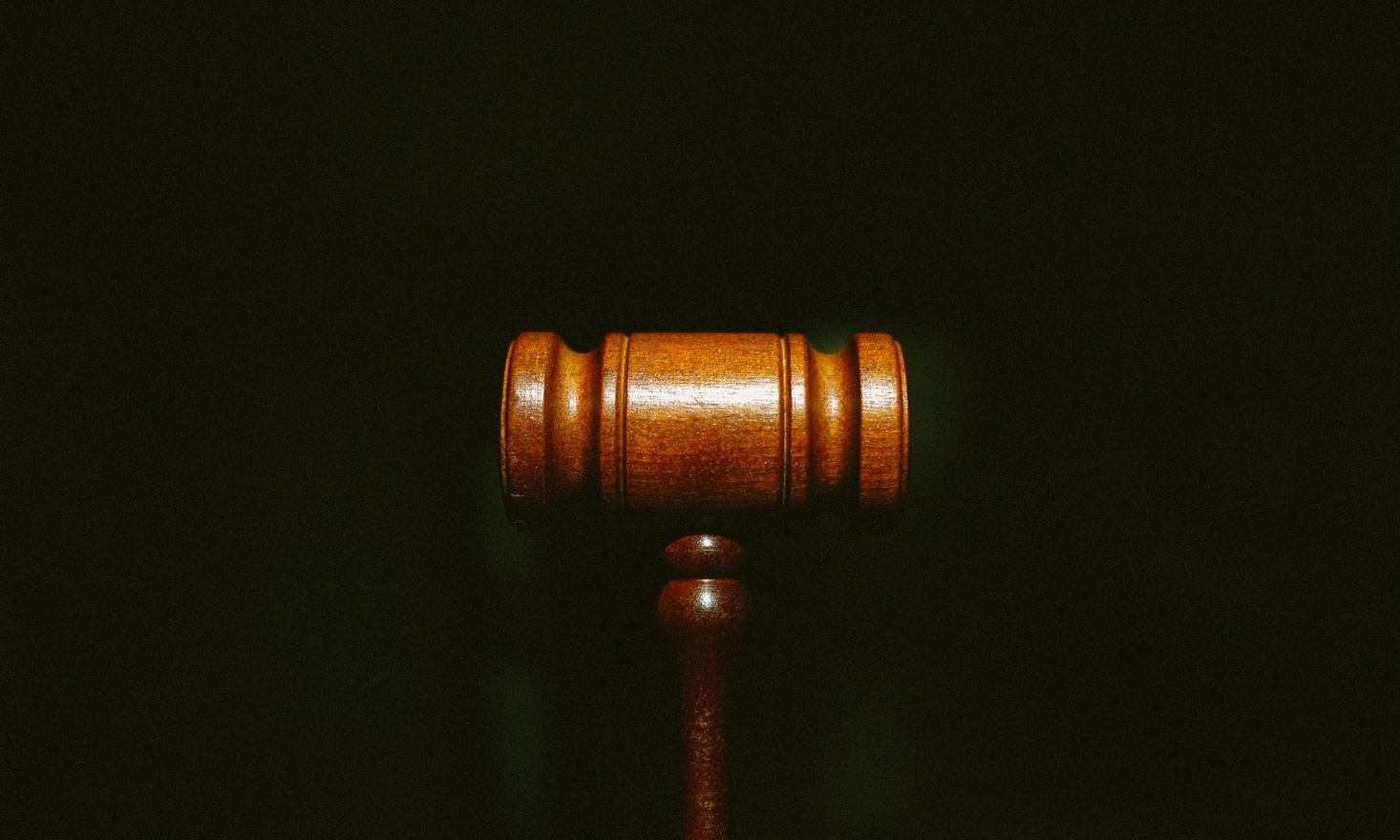 Image of a wooden gavel against a black background.