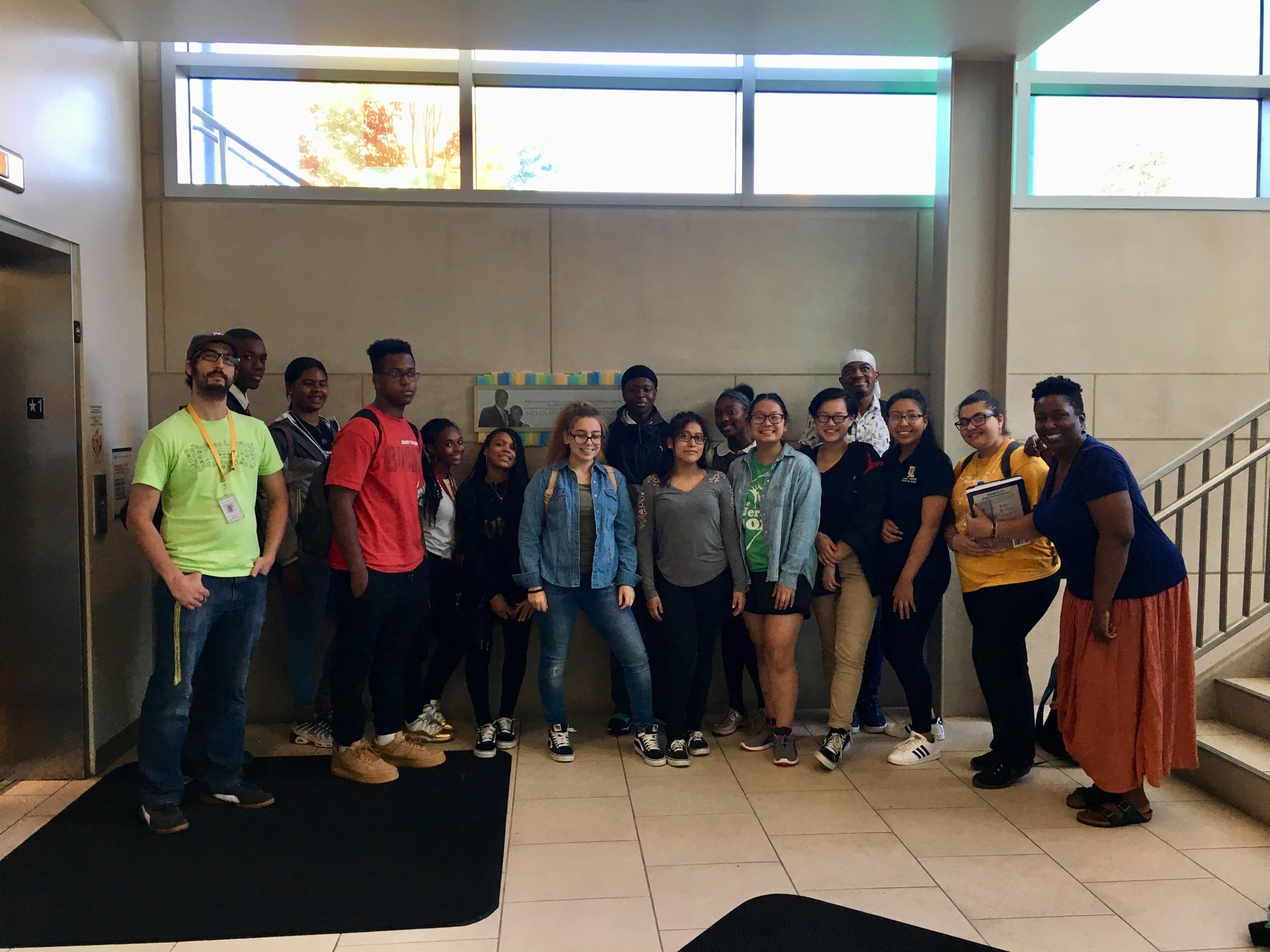 Students in the Karabots Junior Fellows Program pose in front of a plaque devoted to Nicholas and Athena Karabots at the CHOP Karabots Pediatric Care Center