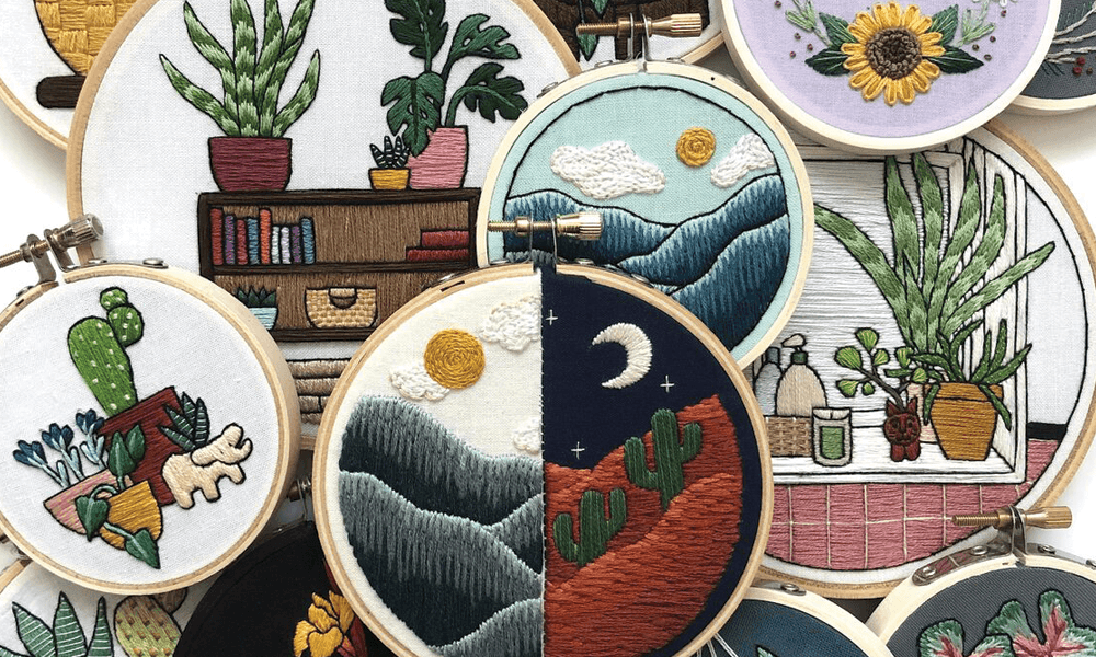 Stacked embroidery hoops with designs of flowers and nature