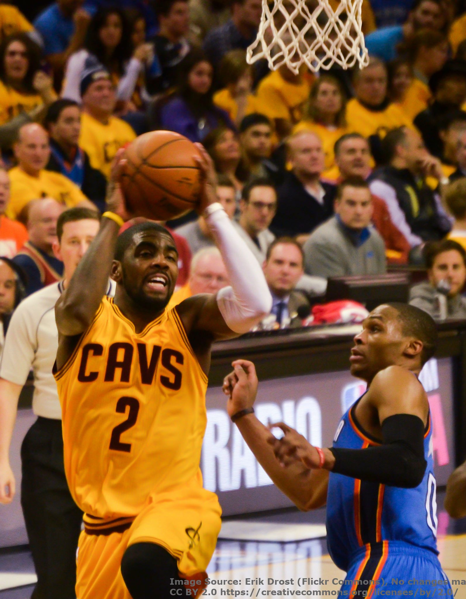 Cleveland Cavaliers point guard Kyrie Irving goes for a layup against a defender.