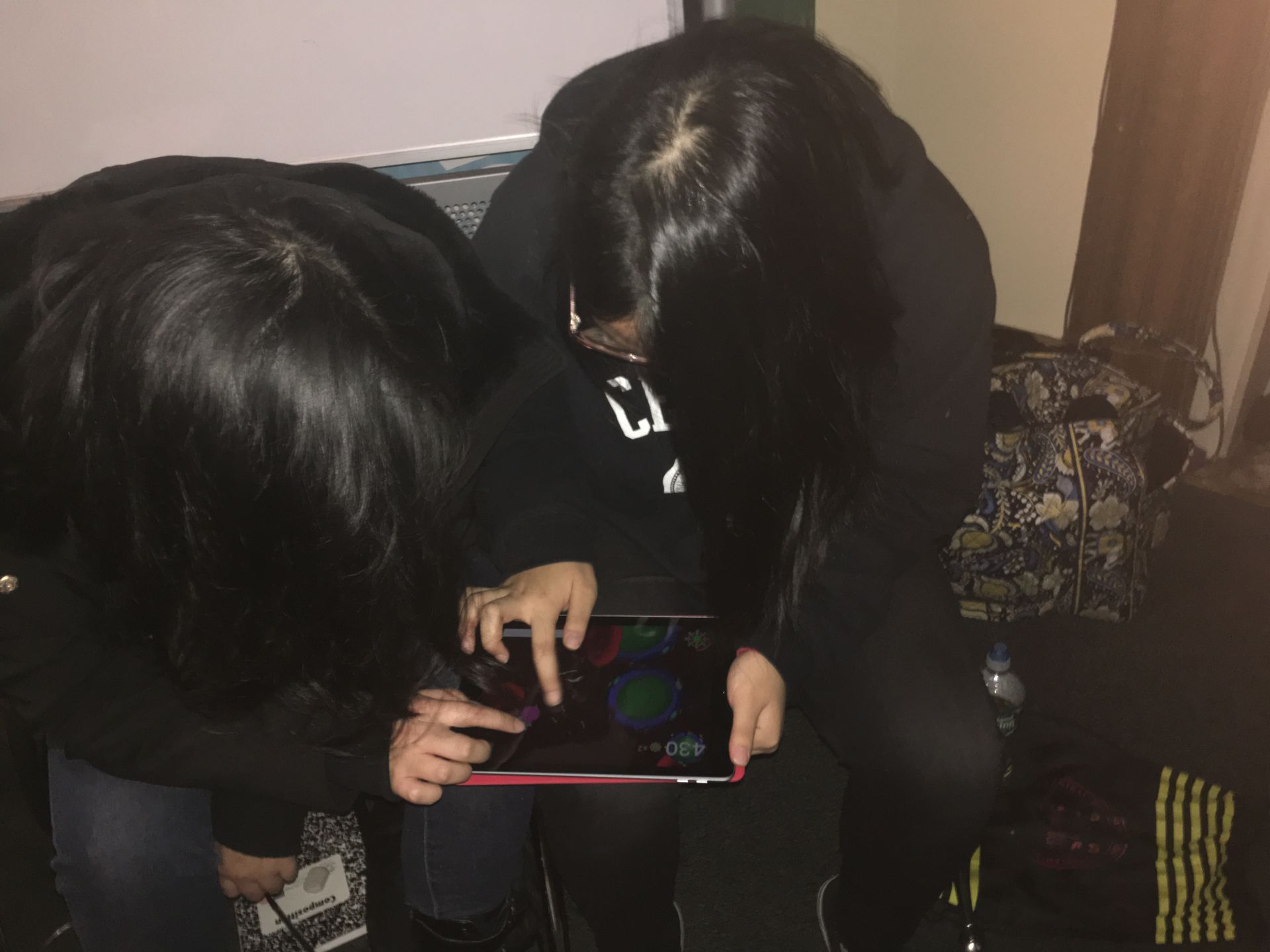 Two students in the Karabots Junior Fellows Program play CD4 Hunter, a mobile game about how HIV infects a healthy cell, on an iPad