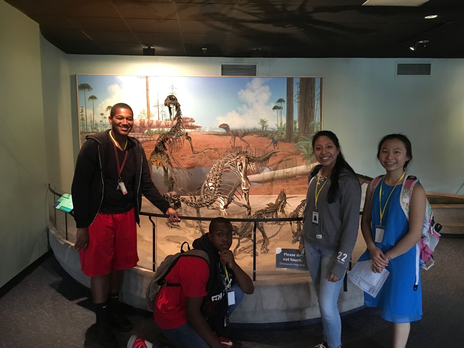 Students in the Karabots Junior Fellows Program pose in front of a dinosaur display at the Academy of Natural Sciences