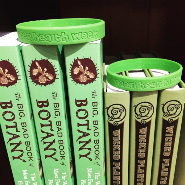 Green "Teen Health Week" wristbands on display atop several Mütter Museum store books.