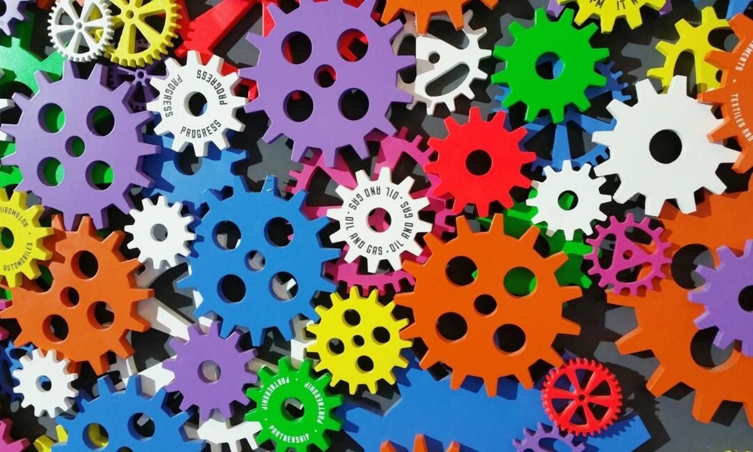 Close up image of multi colored cog and wheels, Center wheel says "Oil and Gas"